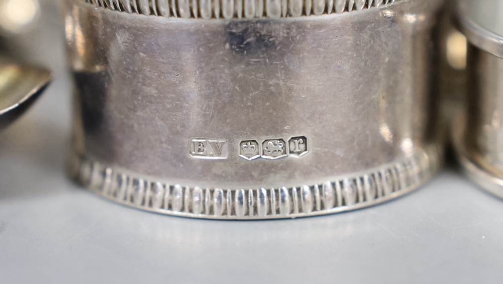 Nine assorted silver napkin rings including a pair of late Victorian and later pair, one other napkin ring and a silver spoon, weighable silver 7oz.